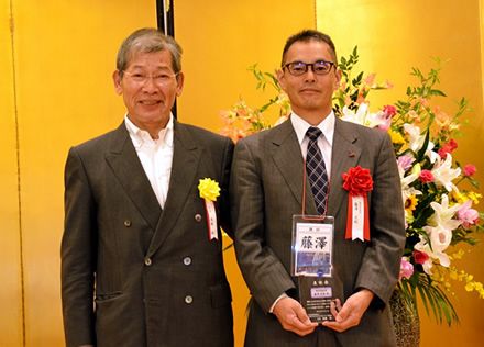 髙橋会長から表彰盾を渡される藤澤さん